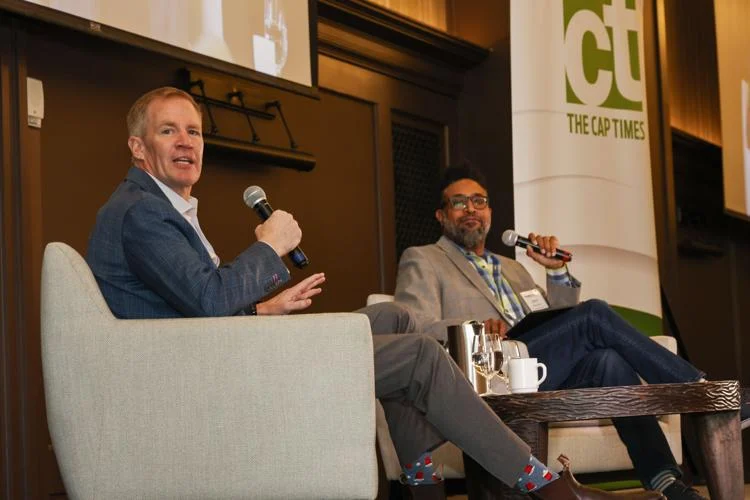 Two men speaking at a conference event.