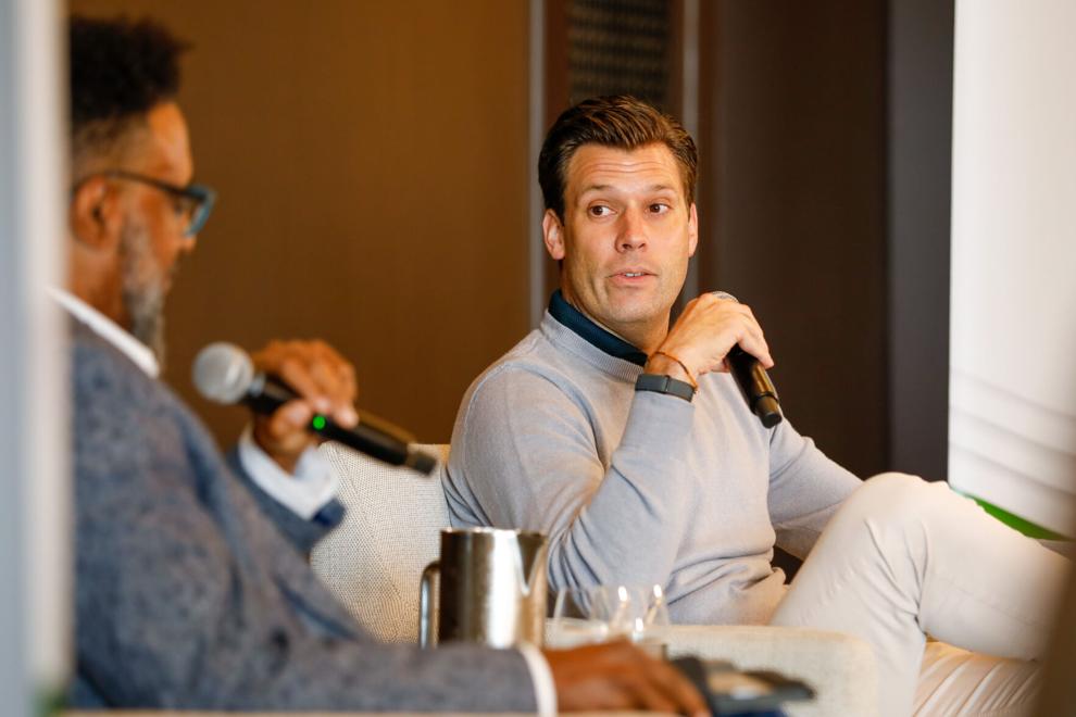 Two men holding microphones in a panel discussion