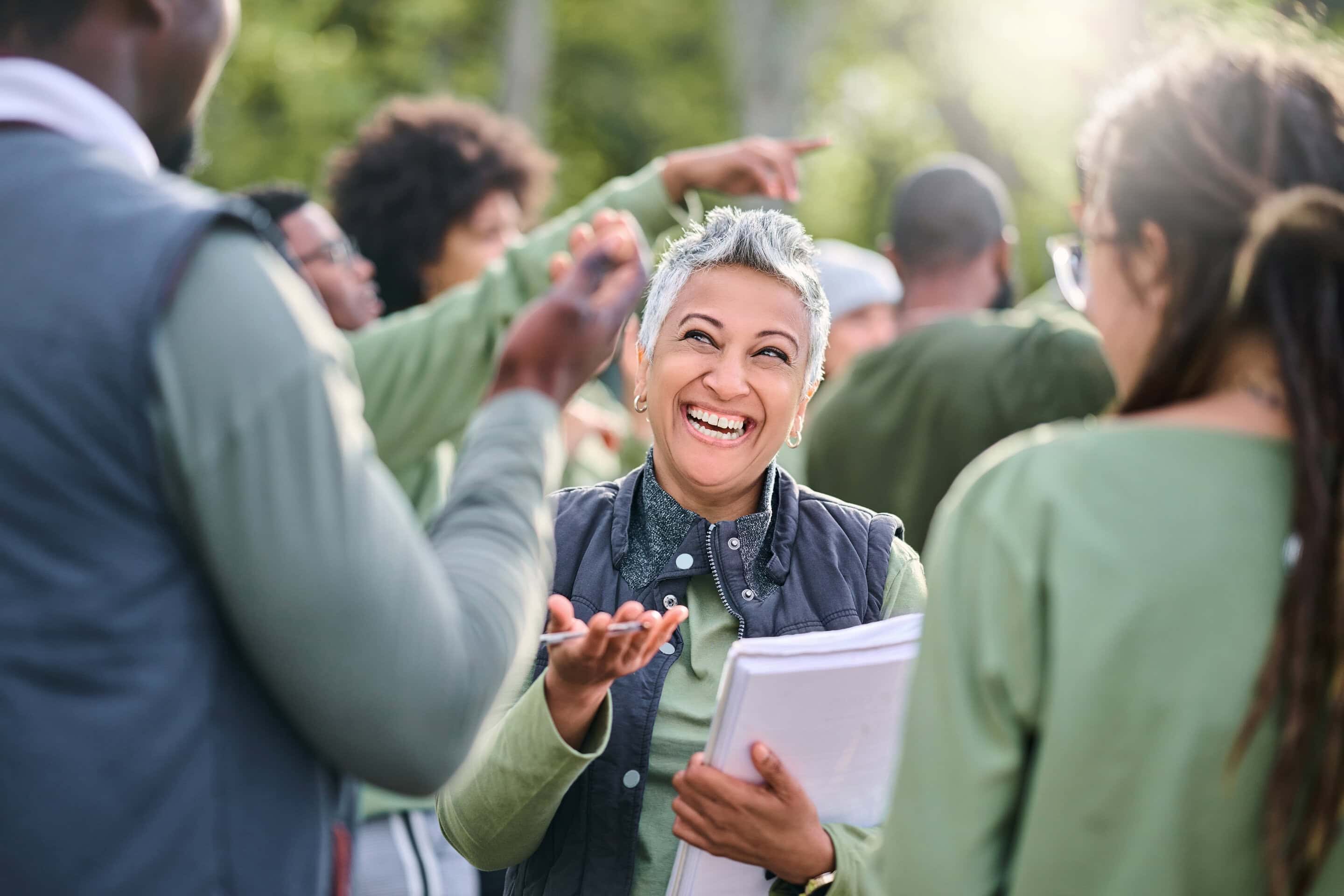 Smiling woman talking in group outdoors.