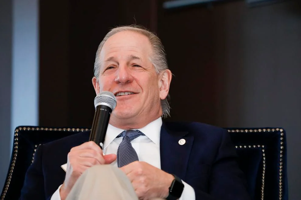 Man speaking into microphone at an event.