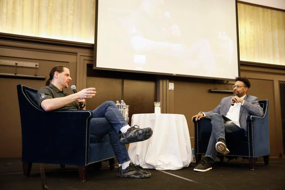 Two men in discussion during a conference.